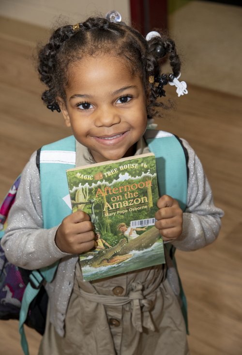 Hazel holding the Magic Tree House book from the Cleveland Kids' Book Bank Hazel holding the Magic Tree House book from the Cleveland Kids' Book Bank