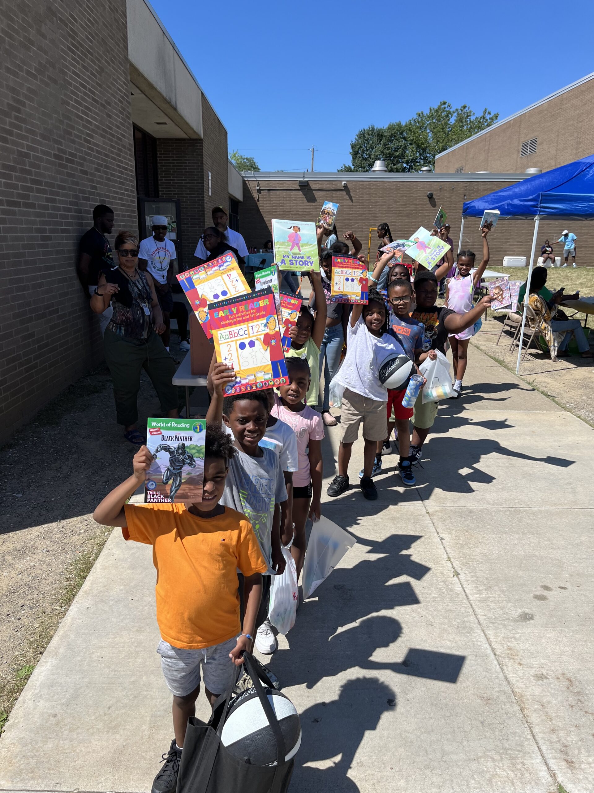 line of children holding books above their heads