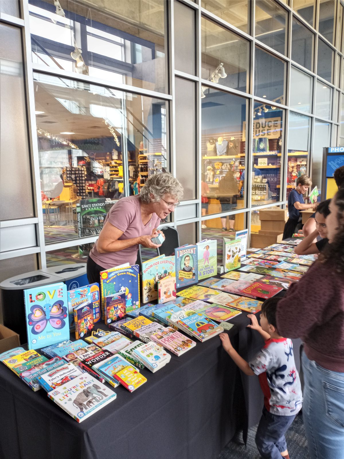 girl holding stack of books looking at the camera